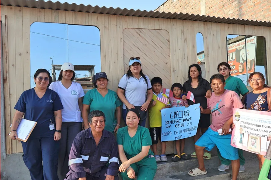 Gustavo Cuba and Dany Ruiz with their three children and Maternidad de María with a thank you sign