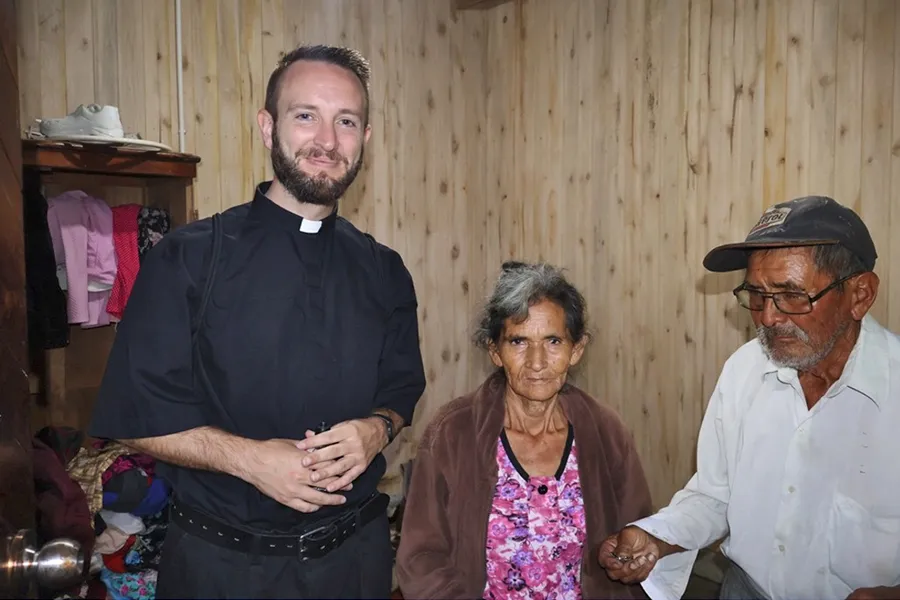 María and Zenón with a local priest in their new home