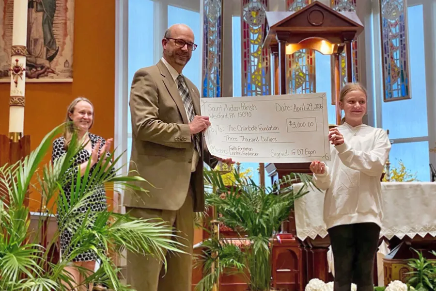 Young girl presenting a check to the Chimbote Foundation's Administrator