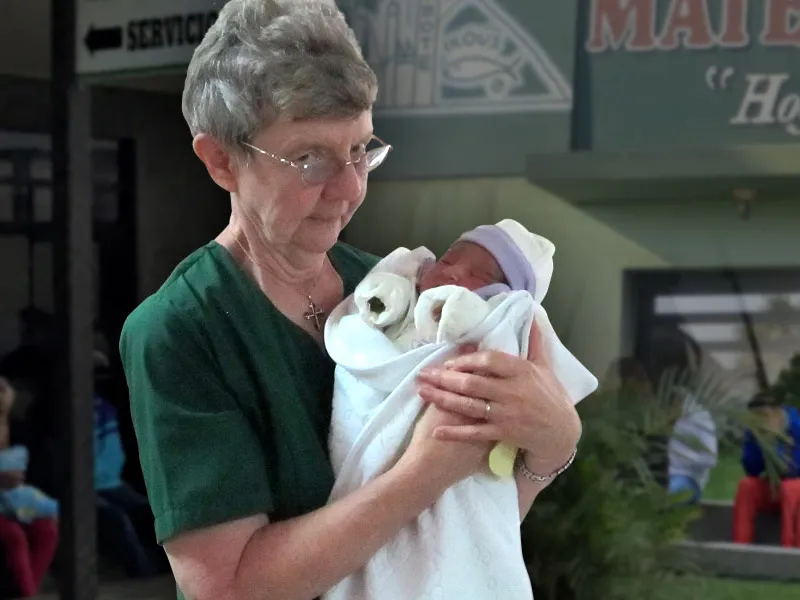 Sister Margaret Mary Birchmeier holding a newborn